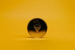 A shiny Ethereum coin displayed on a vibrant yellow background, symbolizing cryptocurrency.